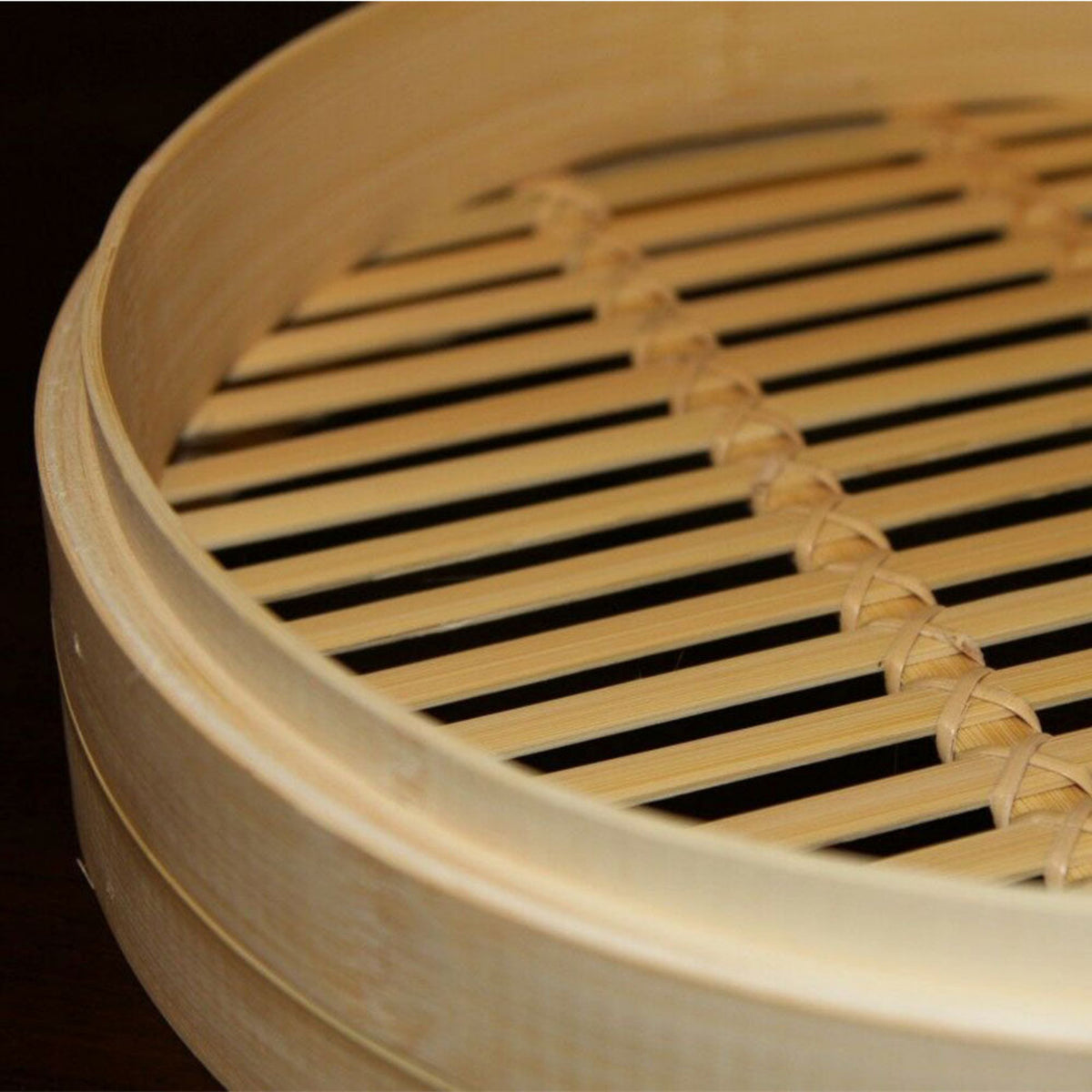 Close-up of a bamboo steamer basket with a dark background